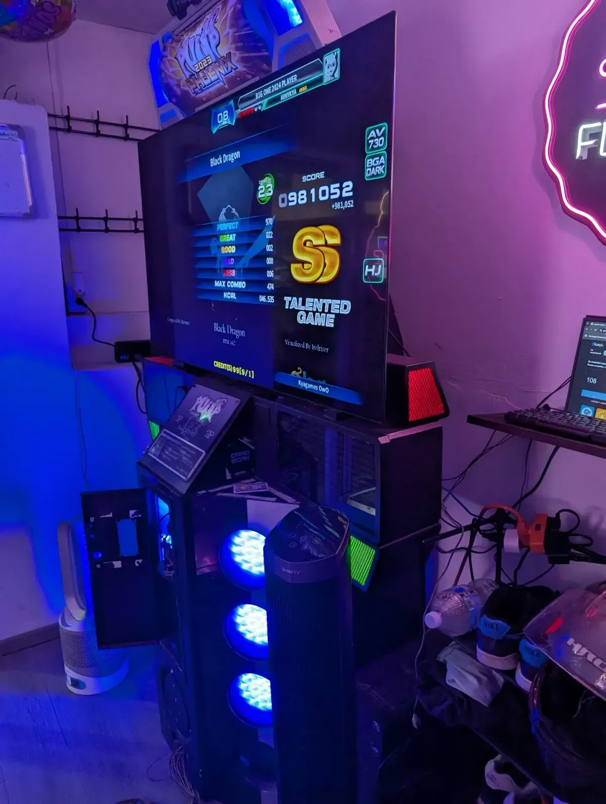 Pantalla de resultado SS en Pump It Up Phoenix junto al letrero neón de La Flechita, arcade en Coyoacán, CDMX